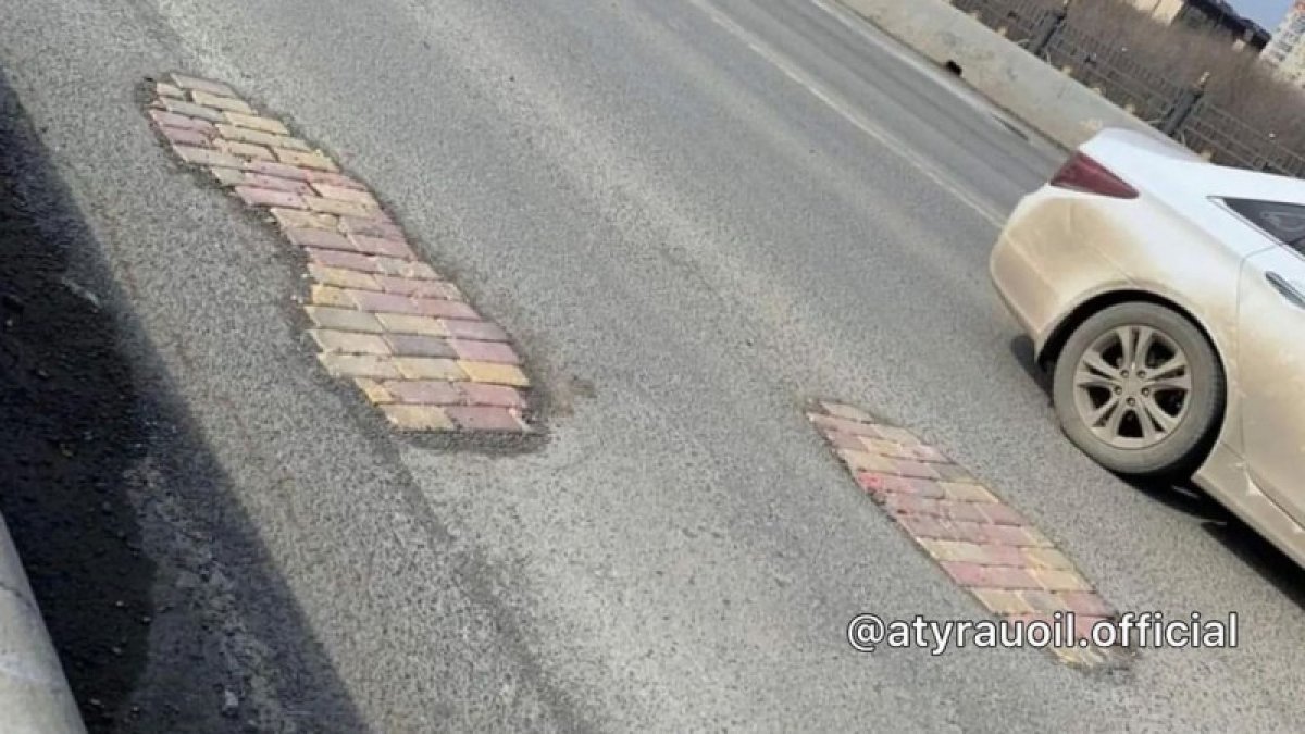 Атырауда асфальттағы тесіктерге кірпіш төселген