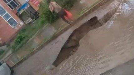 Ақтөбеде жаңбыр кезінде асфальт опырылып, көпқабатты үйде кәріз суы кері ақты